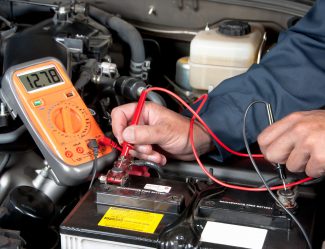 Auto Mechanic Checking Car Battery Voltage